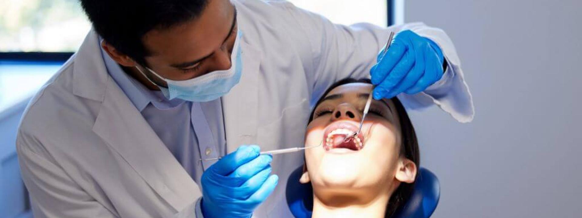 The Oral-Systemic Health Connection: What Your Mouth Says About Your Body Male dentist performing dental work on female patient